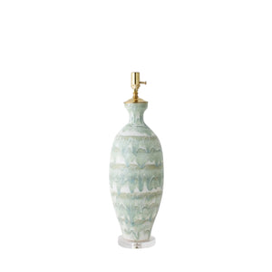 The Elizabeth Lamp in Celadon Drip by Paul Schneider Ceramics features a green and white wavy drip ceramic base, gold fixture, and clear round base, shown without a lampshade against a white background.