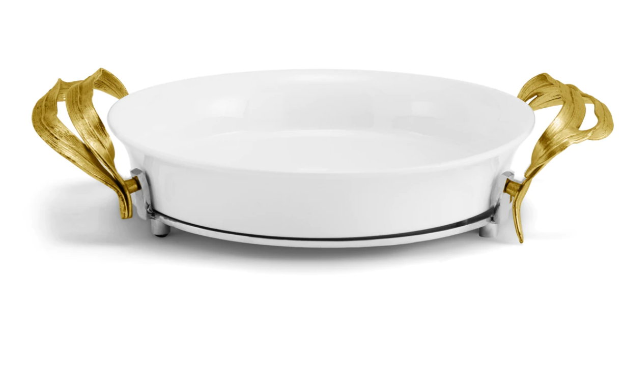The Michael Aram Palm Pie Dish is a white round ceramic serving piece with sculpted textures and gold-tone leaf-shaped metal handles, shown from the front.