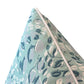 Close-up of the Cowrie Shell Aqua Outdoor Pillow by Associated Design, featuring a white piped edge and abstract leaf shapes in white, blue, and gray on light blue-green, crafted from premium materials.