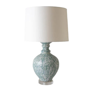 The Hico Lamp in Dappled Blue Green by Paul Schneider Ceramics features a blue-green and white ceramic base with a plain white shade, providing soothing light to enhance your home’s ambiance.