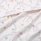 A close-up of the Gooselings Bows & Butterfly Kisses Swaddle, featuring soft pastel bows, flowers, and butterflies on 100% cotton—ideal for a cozy baby swaddle.