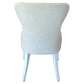 The Lee Industries Curved Back Dining Chair, shown in light beige upholstery, features a gently curved backrest and elegant white wooden legs, offering a sophisticated look when viewed from the back.