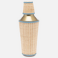A metal cocktail shaker wrapped in rattan with blue leather trim from the Gable Natural/White Barware Collection by Blue Pheasant, shown on a white background.