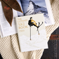 The Ultimate Ski Book by Graphic Image lies on a knitted blanket beside an open magazine with a snowy mountain scene, inviting readers to discover skiing history and culture.