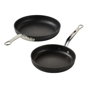 Two Hestan TITUM® Fusion Collection black diamond-reinforced nonstick pans with metal handles are placed on a white background.