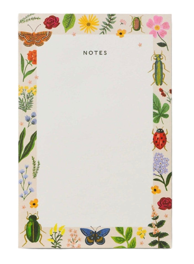 Part of the Curio Desk Accessory Collection by Rifle Paper Co., this notepad has "NOTES" at the top and a border of vibrant insects, flowers, and leaves—perfect for garden lovers on a crisp white background.