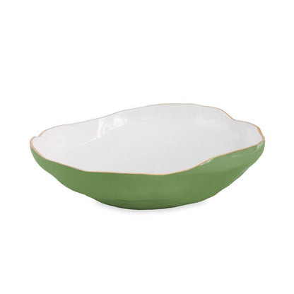 An oval ceramic bowl from Beatriz Ball’s Encanto Leaf Green & White Serveware Collection features a smooth white interior, green exterior, and a subtly wavy rim.