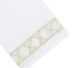 Elevate your home décor with the Haute Home Bamboozle Bath Collection—premium white linen fabric accented by a decorative yellow geometric embroidered trim featuring circles and lines near the edge.
