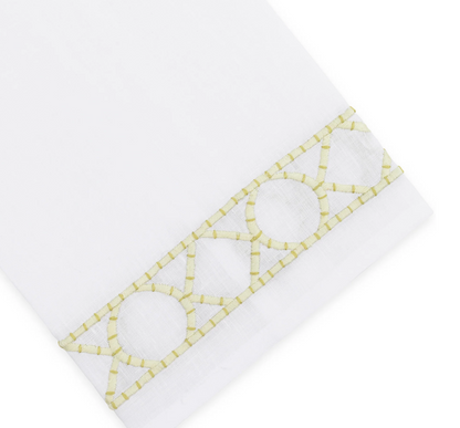 Elevate your home décor with the Haute Home Bamboozle Bath Collection—premium white linen fabric accented by a decorative yellow geometric embroidered trim featuring circles and lines near the edge.