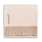 The Alicia Adams Alpaca Classic Herringbone Throw Collection features a folded cream alpaca blanket with beige fringe and a small fabric tag, fair-trade made in Peru, displayed on a white background.