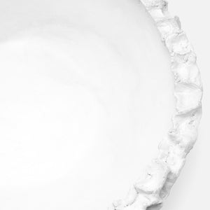A close-up view of the Dara Bowl by Made Goods, featuring a coral-inspired design with a rough, textured rim, crafted from matte white resin.