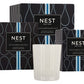 A white Nest Ocean Mist & Sea Salt Candle from the Ocean Mist & Sea Salt Candle Collection is displayed in front of two black patterned boxes, evoking the refreshing aroma of ocean mist and sea salt.