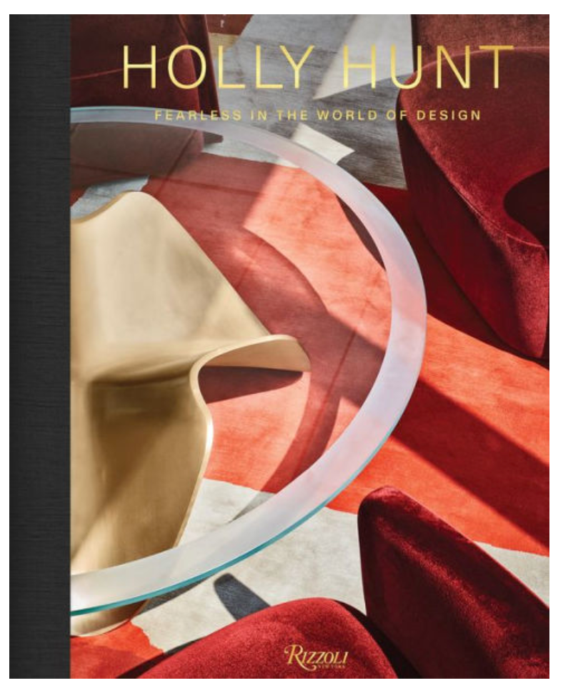 The "Holly Hunt: Fearless In The World of Design" book by Rizzoli features a modern cover with a glass table, abstract gold object, and red velvet chairs on a geometric floor, celebrating bold American design.