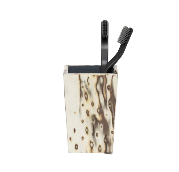 Two black toothbrushes held in a tapered, birdseye burl veneer Bisbee Bath Collection container.