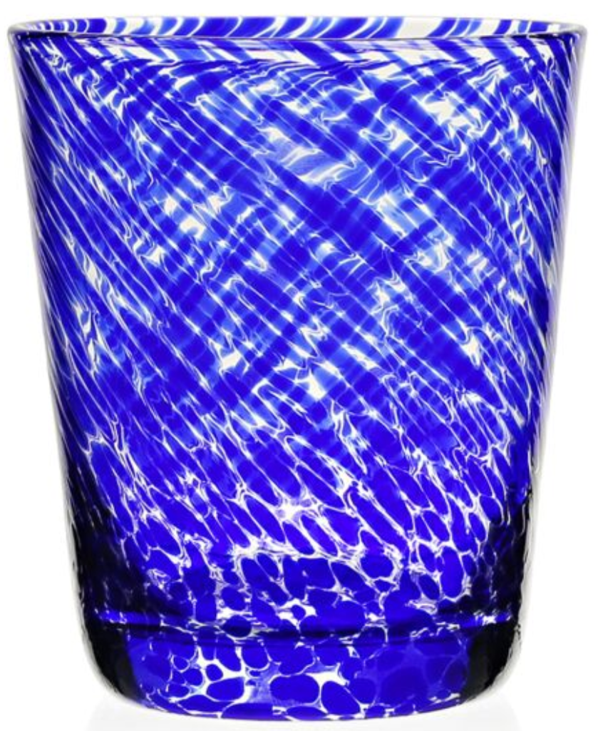 A blue glass tumbler from the Vanessa Blue Drinkware Collection by William Yeoward Crystal features a swirling white optical illusion pattern and a gently tapered shape, shown on a white background.