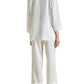 Person wearing Olivia von Halle Fifi Silk Pajamas in white, seen from the back—featuring long sleeves and wide-leg pants, styled with white heeled sandals for an elegant silk pajama look.
