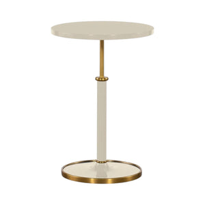 Highland House Olsen Accent Table, a round cream-colored lacquer table with a central post and a metallic brass base.