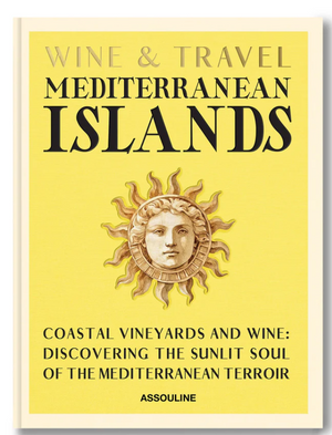 Assouline’s "Wine & Travel Mediterranean Islands" book cover features a sun with a face on a yellow background, with black and gold text highlighting vineyard journeys from Sicilian wines to Greek Assyrtiko discoveries.