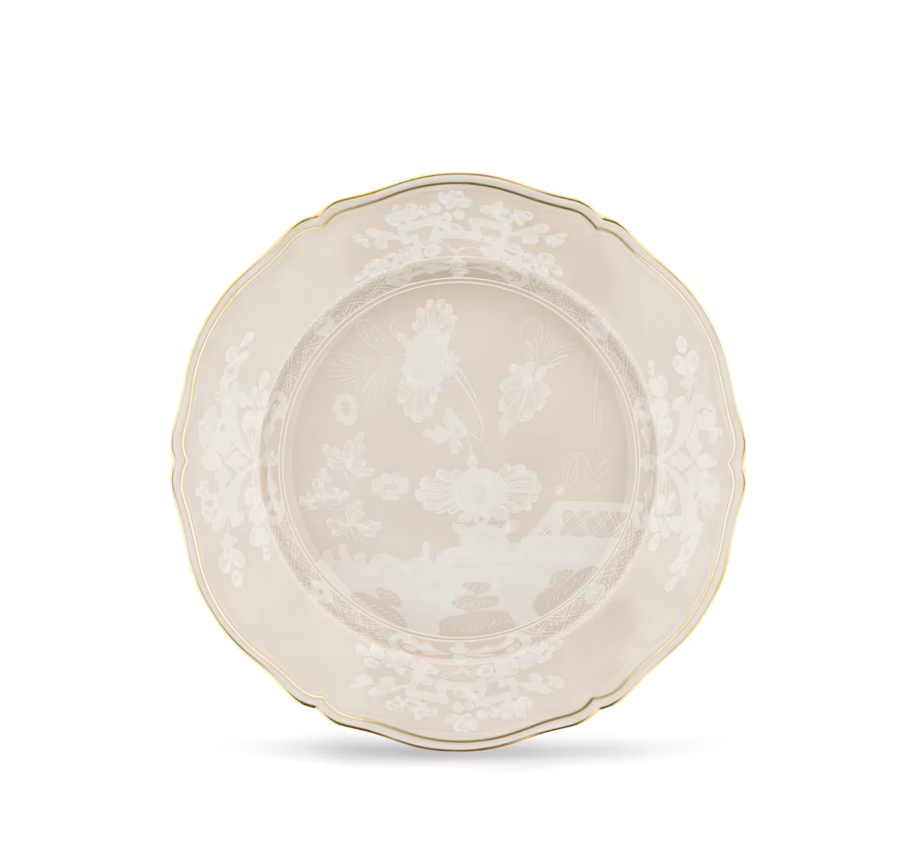 The Oriente Italiano Meringa Dinnerware & Serveware Collection by Ginori 1735 is showcased on a plain white background, featuring ivory porcelain plates adorned with scalloped edges, elegant gold trim, and an intricate white floral and garden motif at the center and along the rim—beautifully exemplifying the timeless artistry of Ginori 1735 porcelain tableware.