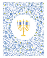The Menorah and Doves Boxed Card Set by Caspari features a golden menorah with eight blue candles and one yellow candle, centered in a floral and dove-patterned blue and white border—making it an ideal choice for greeting cards crafted on FSC-certified cardstock.
