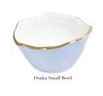 A small, light blue wavy-rim bowl with gold trim made from aluminum alloy—labeled "Osaka Small Bowl"—from Beatriz Ball's Encanto Periwinkle Serveware Collection.