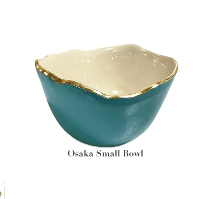 A small bowl from Beatriz Ball's Encanto Turquoise Serveware Collection features a glossy teal enameled aluminum exterior, cream interior, and gold-rimmed edge. Text below reads "Osaka Small Bowl.