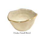 The Encanto Cream Serveware Collection by Beatriz Ball features a small, cream-colored aluminum alloy bowl with gold trim and an irregular rim, called the Osaka Small Bowl.