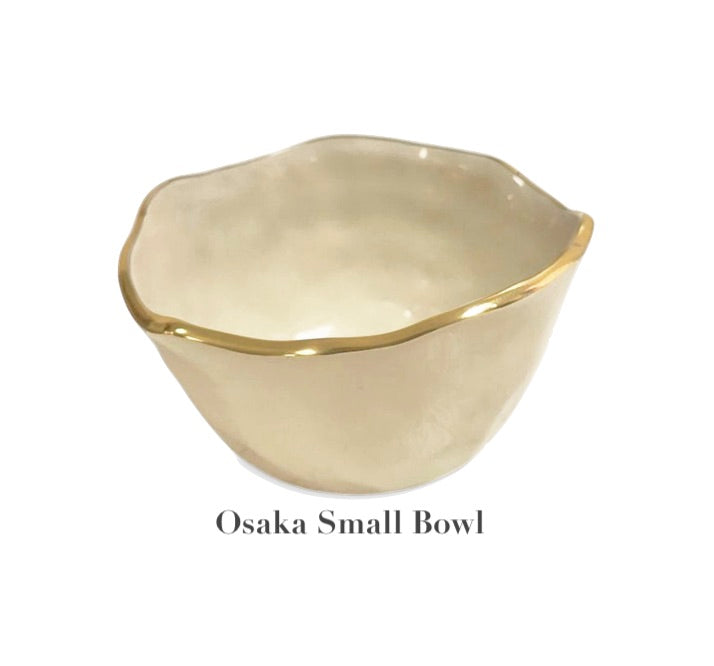 The Encanto Cream Serveware Collection by Beatriz Ball features a small, cream-colored aluminum alloy bowl with gold trim and an irregular rim, called the Osaka Small Bowl.