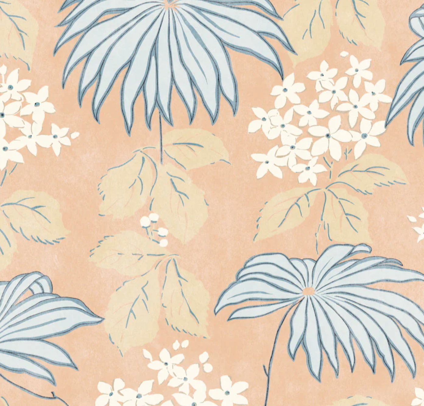 The Bellini Pillow by Hive Custom Pillows features large blue leaves and white flowers with greenish stems on a peach background, crafted with care. Pair it with other custom pieces to elevate any space.