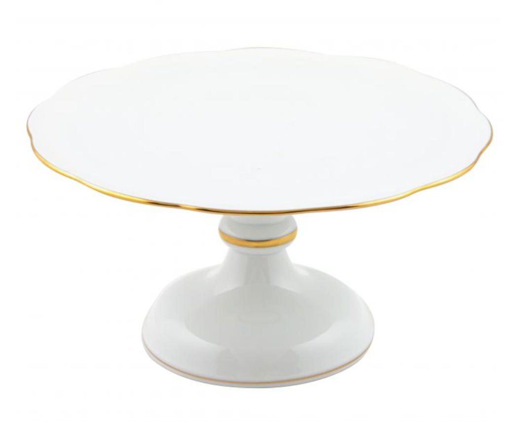 The Herend White and 24k Gold Footed Cake Plate features a hand-painted porcelain design with a scalloped edge, gold trim, and wide pedestal base, shown against a plain background.