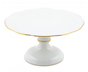 The Herend White and 24k Gold Footed Cake Plate features a hand-painted porcelain design with a scalloped edge, gold trim, and wide pedestal base, shown against a plain background.