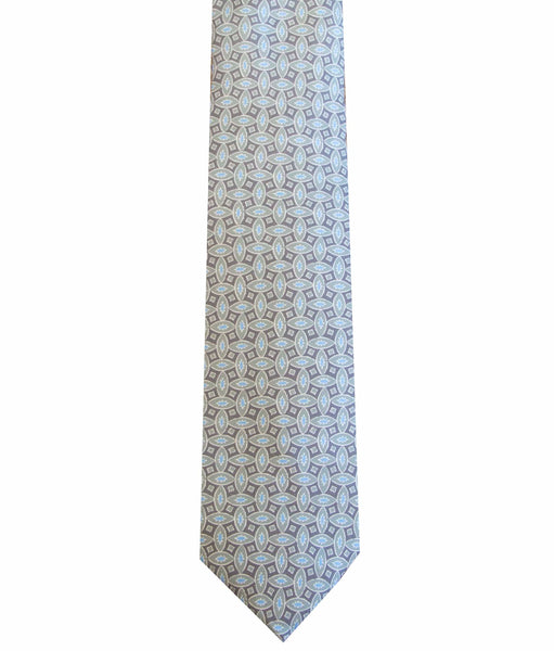A close-up image of a Robert Jensen Geo Oval Print Tie, Grey and Blue featuring an intricate pattern of blue and white geometric shapes, meticulously handcrafted by traditional artisans.