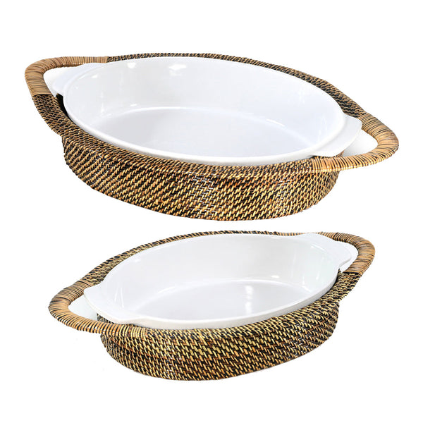 Two Calaisio Oval Stoneware Roasters, set slightly askew against a white background, feature woven rattan frames. These elegant casserole baskets by Calaisio combine style and function, ideal for serving meals beautifully.