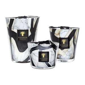 Three Baobab Collection Stones Marble Candles by Baobab, featuring marbled black, white, and gold hand-blown glass in varying heights, are arranged side by side on a white background.
