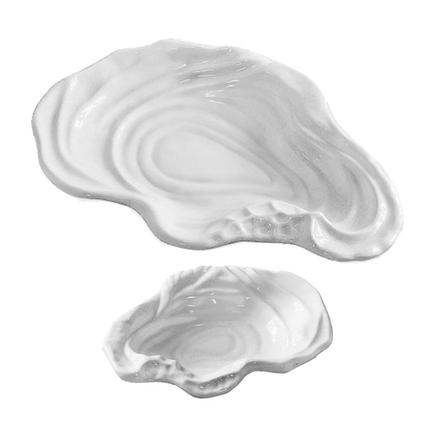 The Beatriz Ball Vida Ocean Oyster Bowl Collection features two white luxury melamine plates, one large and one small, shaped like oyster shells—ideal for indoor and outdoor entertaining. Displayed on a white background.