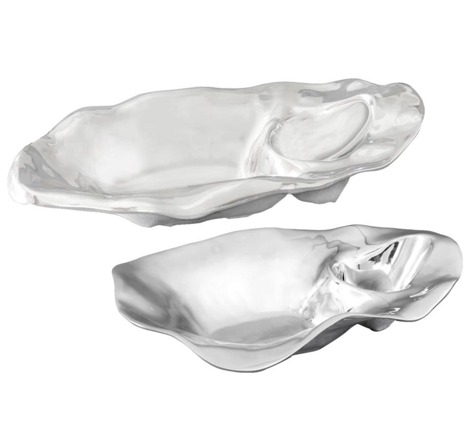 The Beatriz Ball Ocean Oyster Champagne Bucket Collection features two metallic, irregularly-shaped serving dishes, each crafted from aluminum alloy with a shallow main area and a smaller, scooped section on one side.