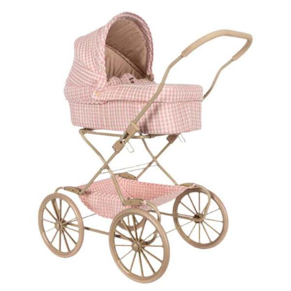 The Konges Slojd Doll Pram by Konges Slojd is a vintage style doll carriage crafted with quilted fabric and adorned in a pink and beige plaid design. It features large wheels, a curved handle, and includes a cushioned storage basket.