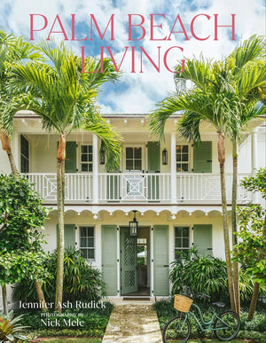 The cover of Palm Beach Living by Vendome shows a white two-story house with green shutters, lush palm trees, tropical plants, and a bicycle in front—a vibrant scene capturing the essence of tropical living.