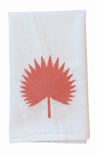 Introducing the Haute Home Palm Leaf Bath Collection: a white Italian linen cloth napkin adorned with a coral pink embroidered palm leaf motif at its center.