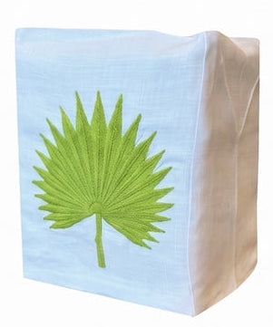 Elevate your space with the Haute Home Palm Leaf Bath Collection: a white Italian linen tissue box cover featuring an embroidered green palm leaf design on the front, echoing the refined look of an elegant tip towel.