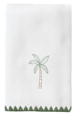 The Palm Tree Green Stitched Guest Towel by Weezie Towels is an absorbent white cotton towel with a central embroidered palm tree and green zigzag trim at the bottom.