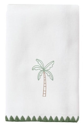 The Palm Tree Green Stitched Guest Towel by Weezie Towels is an absorbent white cotton towel with a central embroidered palm tree and green zigzag trim at the bottom.