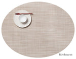 A beige Oval Placemat by Chilewich features a small white plate, a white bowl, and a red chopstick in the upper left, ideal for any dining setting; "Parchment" is shown at the bottom right.