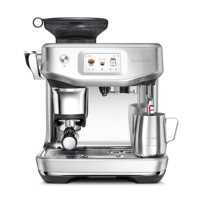 The Breville Barista Touch Impress Espresso Machine features a stainless steel design, digital display, built-in grinder, Impress Puck System, portafilter, and a steam wand frothing milk in a metal cup.