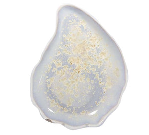 The Large Oyster Plate from AE Ceramics features an irregular shape and a glossy pale blue finish with cream speckles, part of the Oyster Collection.