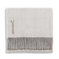 Alicia Adams Alpaca's Classic Herringbone Throw Collection features a folded light gray baby alpaca wool blanket with a darker gray fringed edge and fabric label, ethically crafted in Peru.