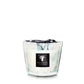 A Baobab Pearls Sapphire candle in a hand-blown glass container with a swirling white and turquoise design.