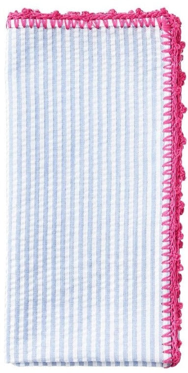 The Kim Seybert Seersucker Napkin Set features blue and white stripes with a pink hand-crocheted border.