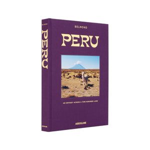 Peru, An Odyssey Across a Time Honored Land" by Assouline is a hardcover book with a purple cover featuring a llama in front of mountains and a volcano—ideal inspiration for Peru travel or dreaming of Machu Picchu.