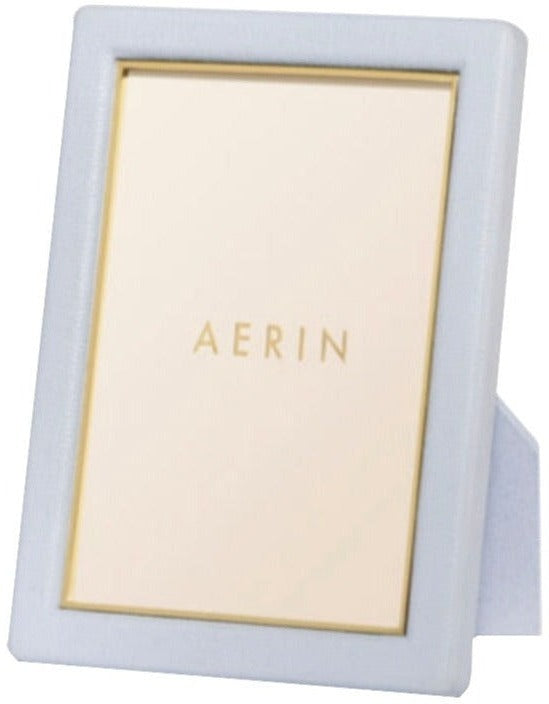 A rectangular Piero Leather Frame from AERIN in light blue with gold detailing and a stand—an elegant way to showcase your cherished memories.
